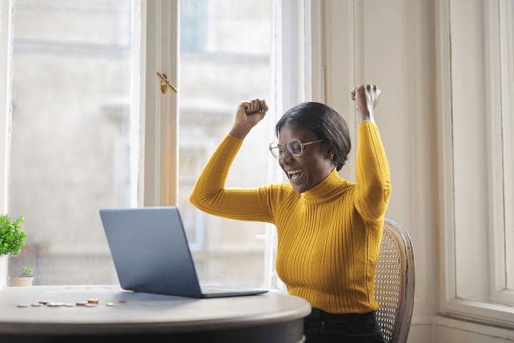 Photo d'une femme heureuse de recevoir son virement suite au rachat de ses cartouches d'encre